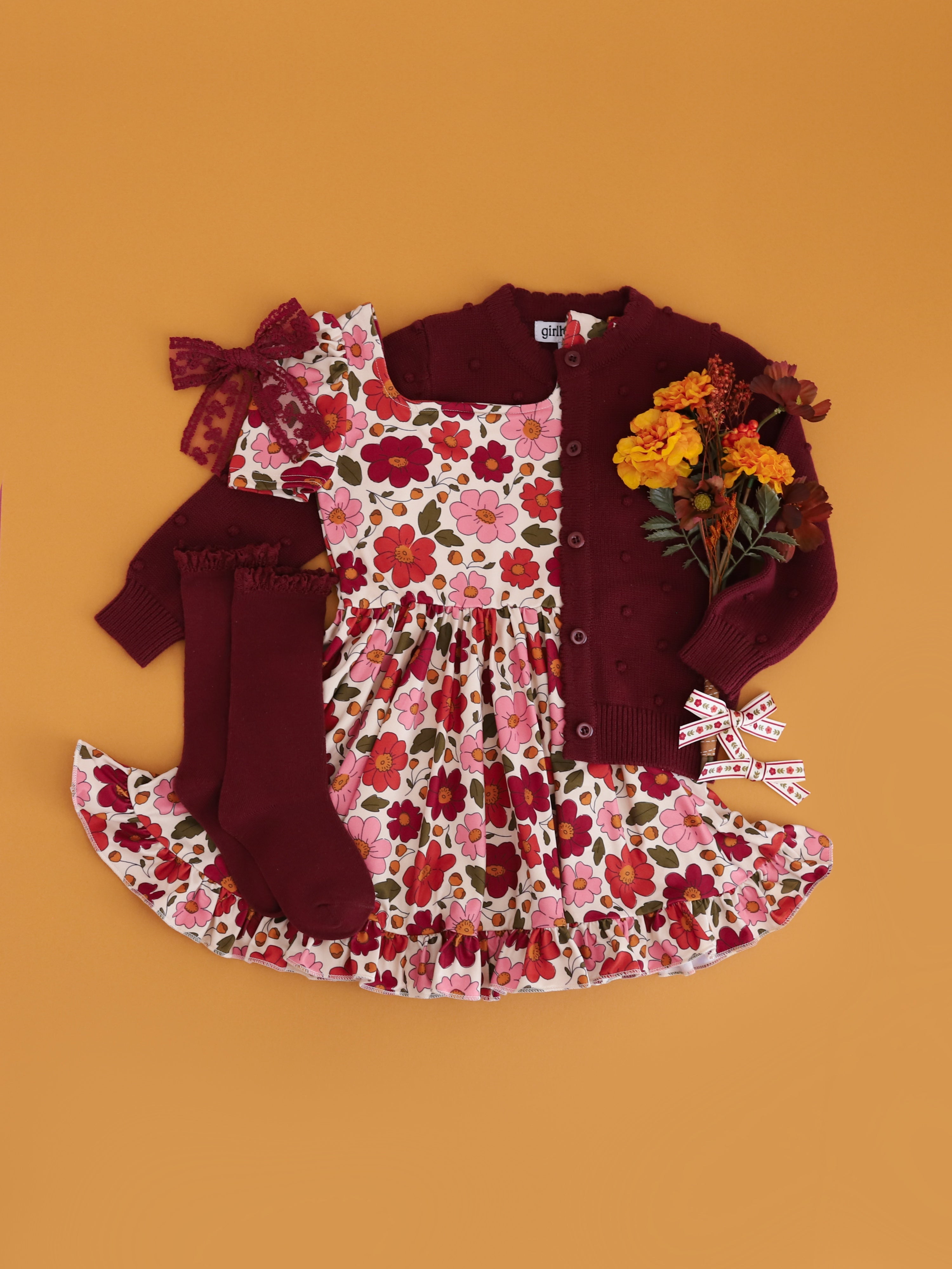 girls' vanilla twirl dress with rust, pink and burgundy floral print paired with burgundy cotton knit cardigan, knee socks and lace hair bow
