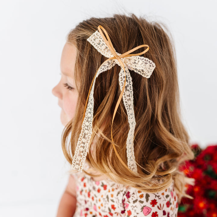 young girl in fall floral dress paired with cream lace and mustard ribbon hair bow on clip