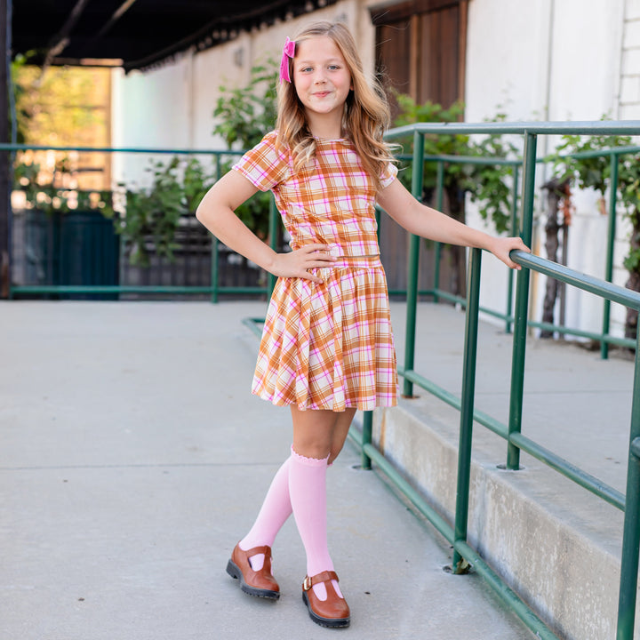 girl in cream velvet plaid skort and matching top with pink lace top knee highs and pink velvet ribbon hair bow for fall