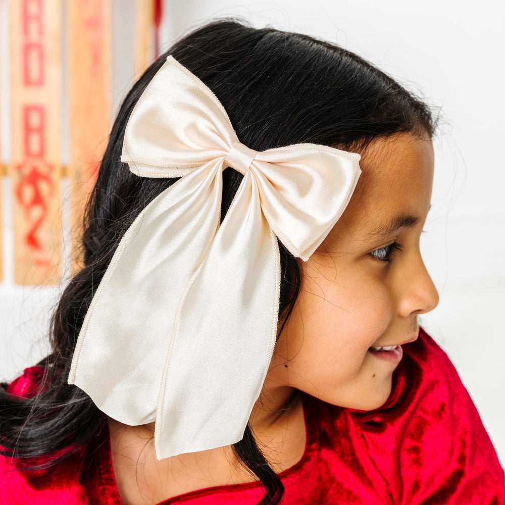 girl in crimson velvet Christmas dress and cream satin oversized double bow on clip