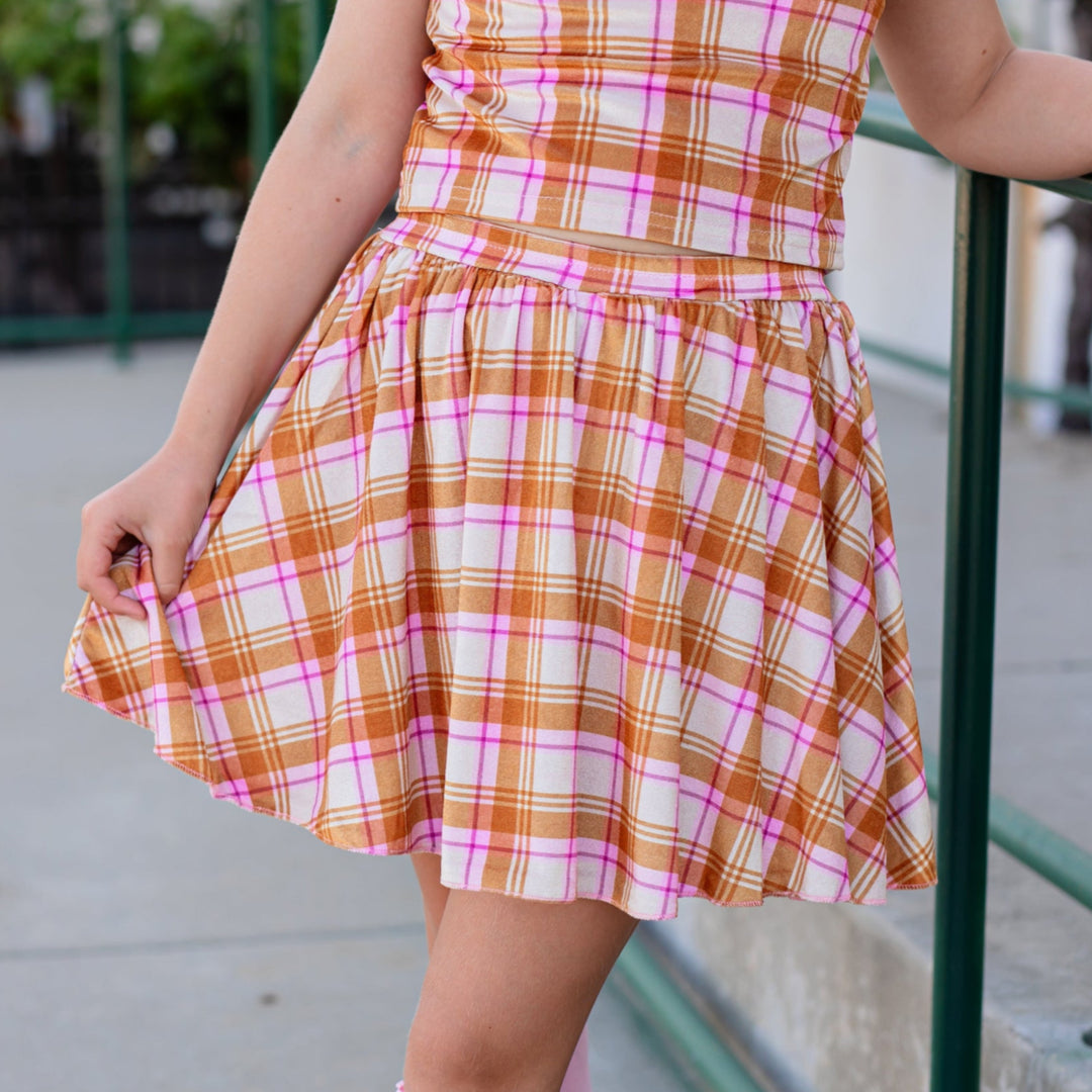 closeup of girl in cream plaid velvet skort with matching velvet plaid top and pink lace top knee highs for fall