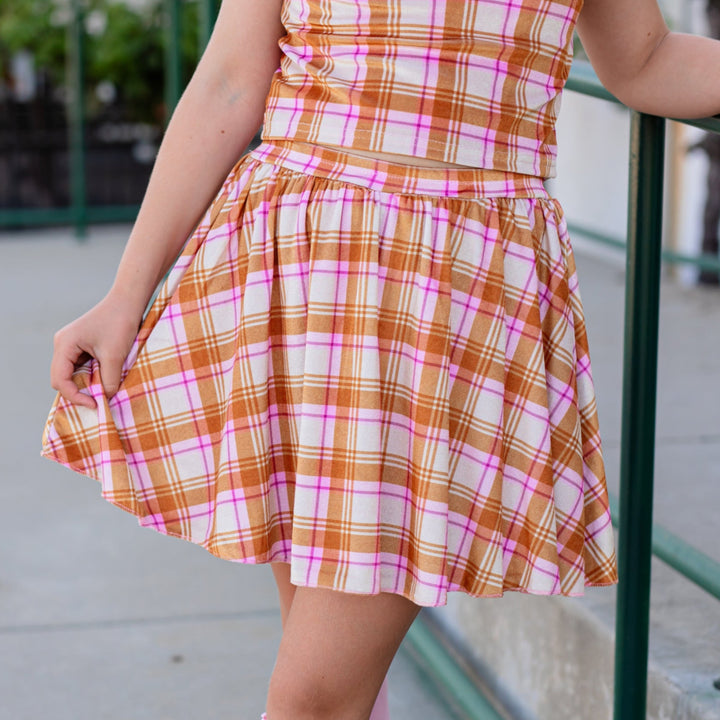 closeup of girl in cream plaid velvet skort with matching velvet plaid top and pink lace top knee highs for fall