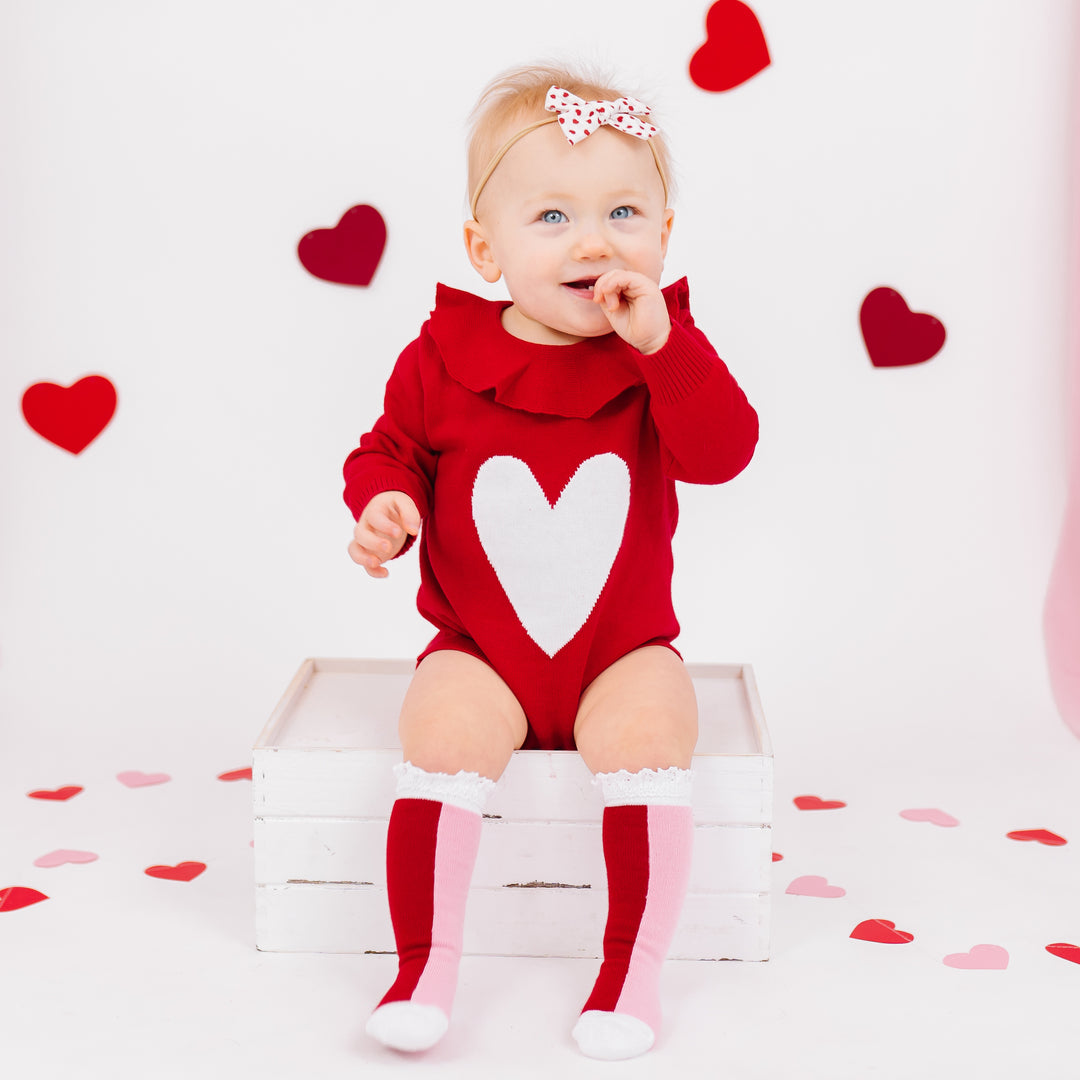 baby girl in red and white romper with two-tone red and pink valentines day socks