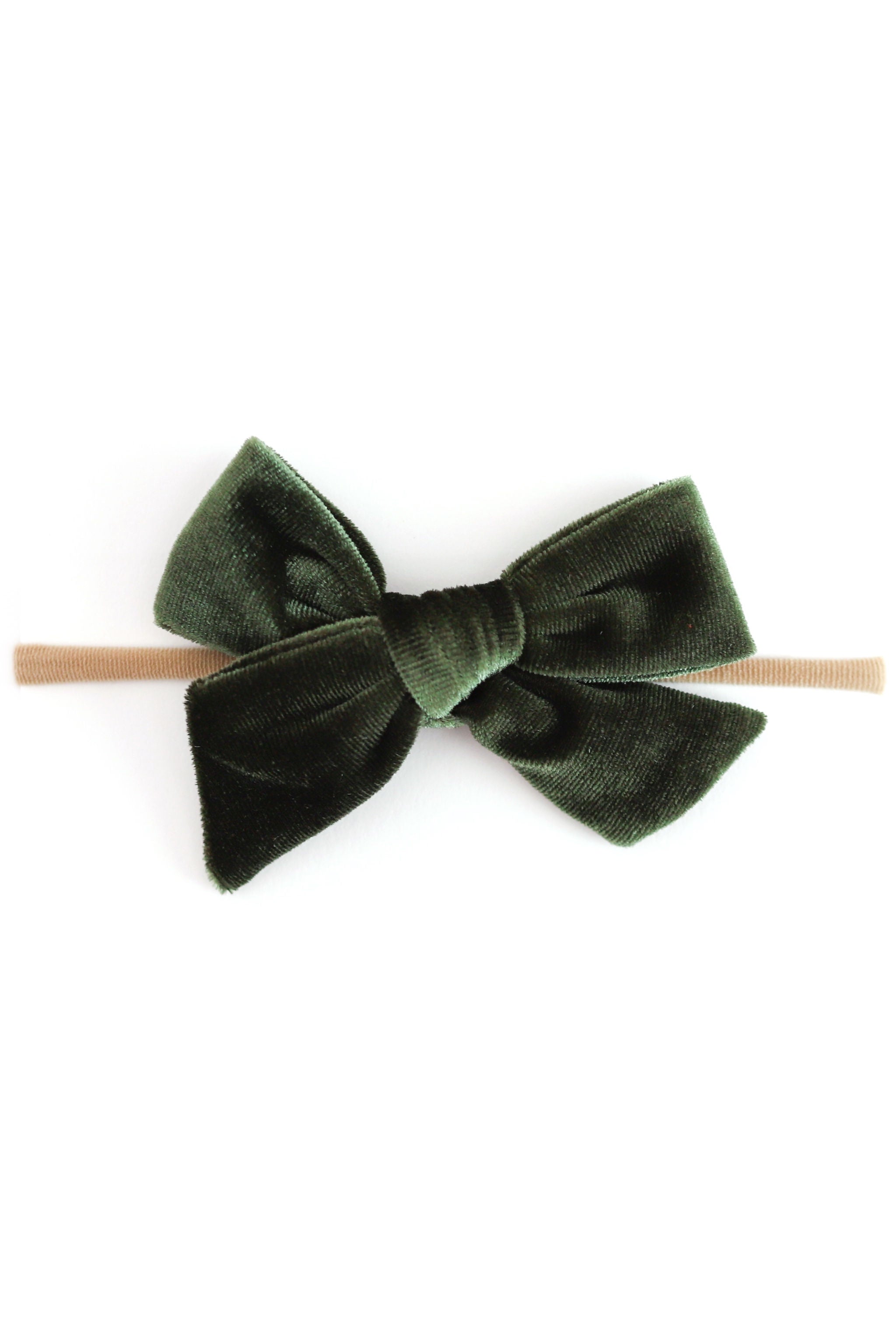 green velvet baby bow on nylon headband photographed on plain white background