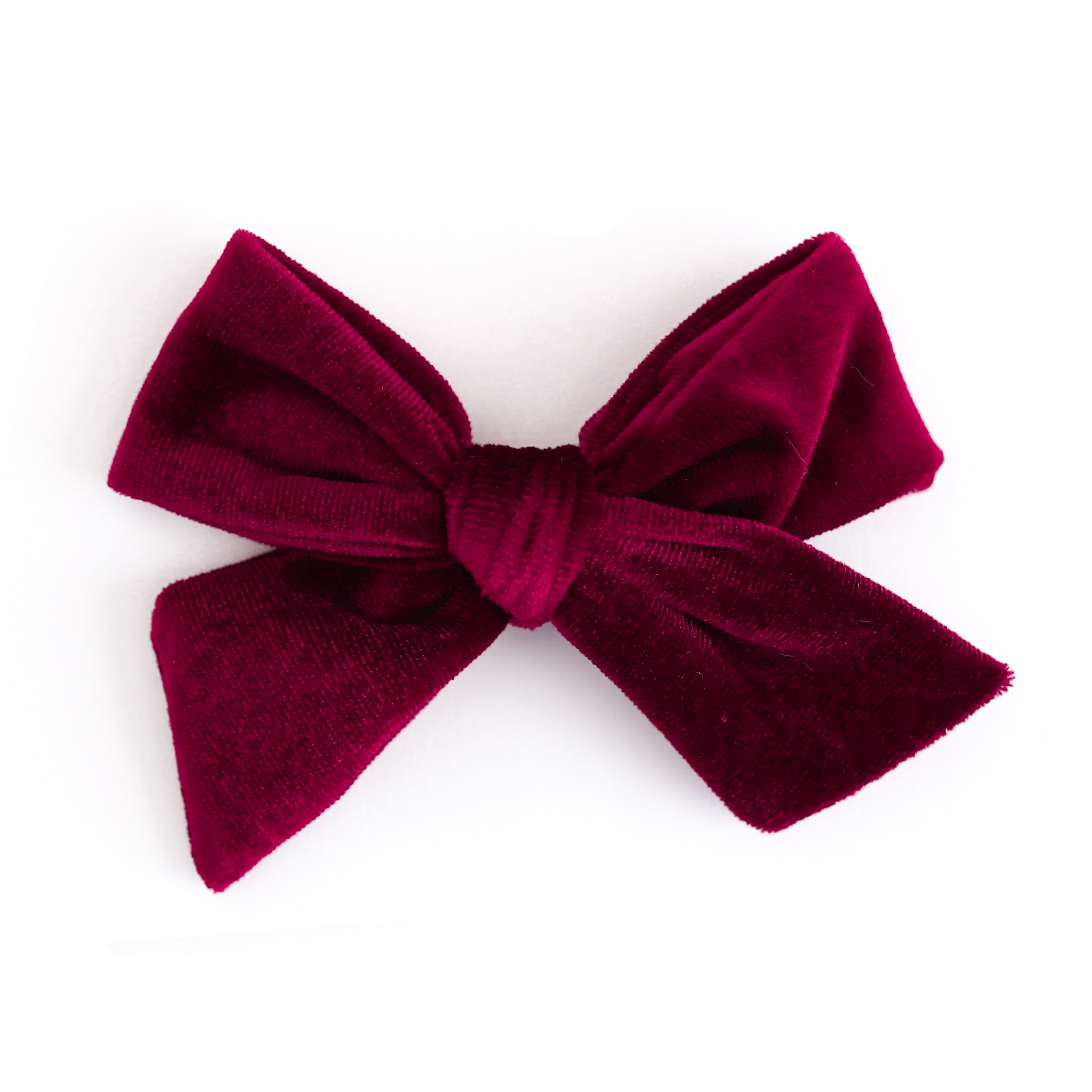 A deep burgundy velvet bow accessory, photographed against a seamless white background.