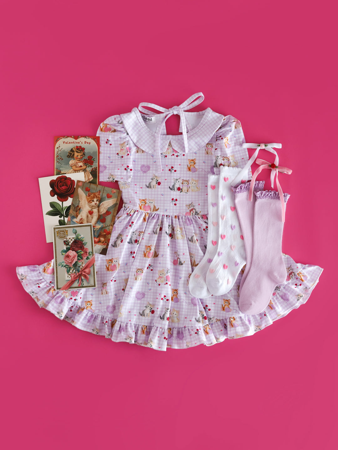 girls vintage inspired Valentine's day outfit styled with vintage valentine cards, kitten print gingham twirl dress and matching socks and haor bows
