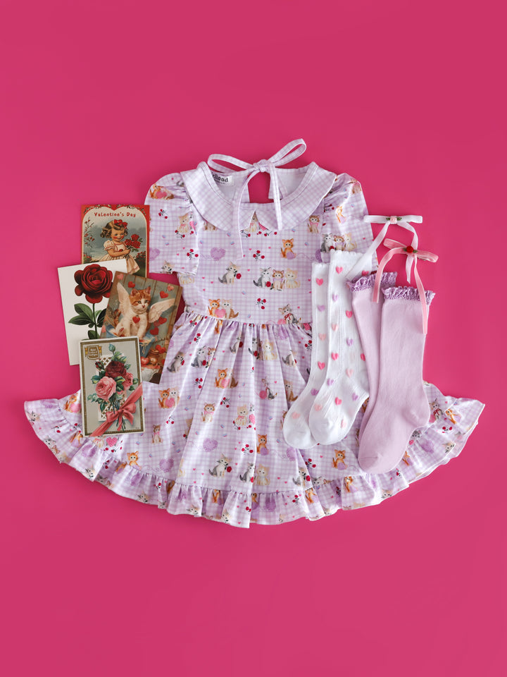 girls vintage inspired Valentine's day outfit styled with vintage valentine cards, kitten print gingham twirl dress and matching socks and haor bows