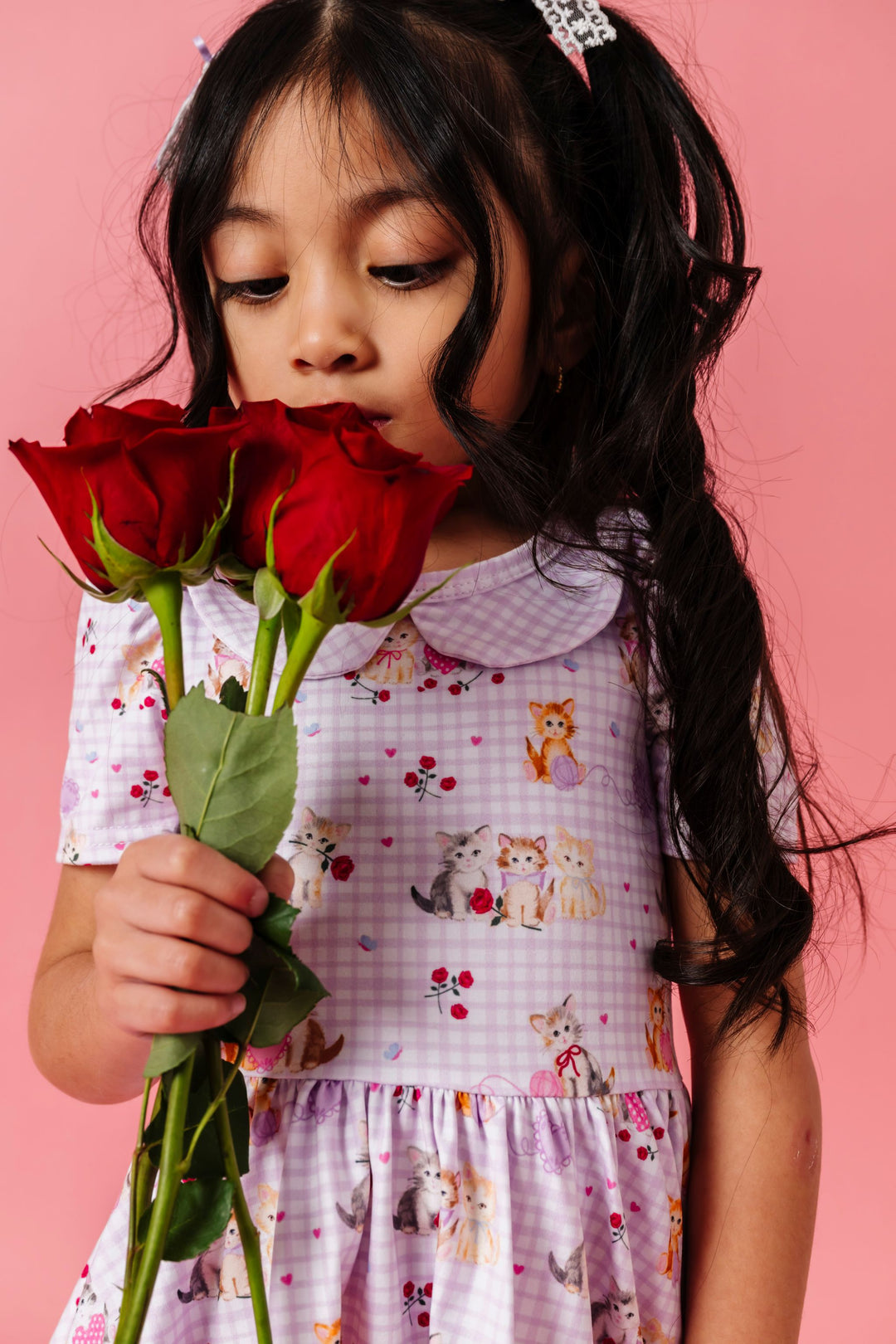 little girl holding red roses in lavender gingham twirl dress with vintage kittens and roses for valentines day