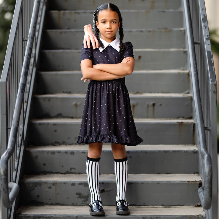 little girl in Wednesday Addams inspired halloween dress and knee socks