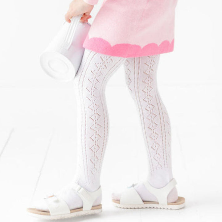 detail photo of girl in white open knit tights paired with pink spring sweater skirt with contrast scallop print trim