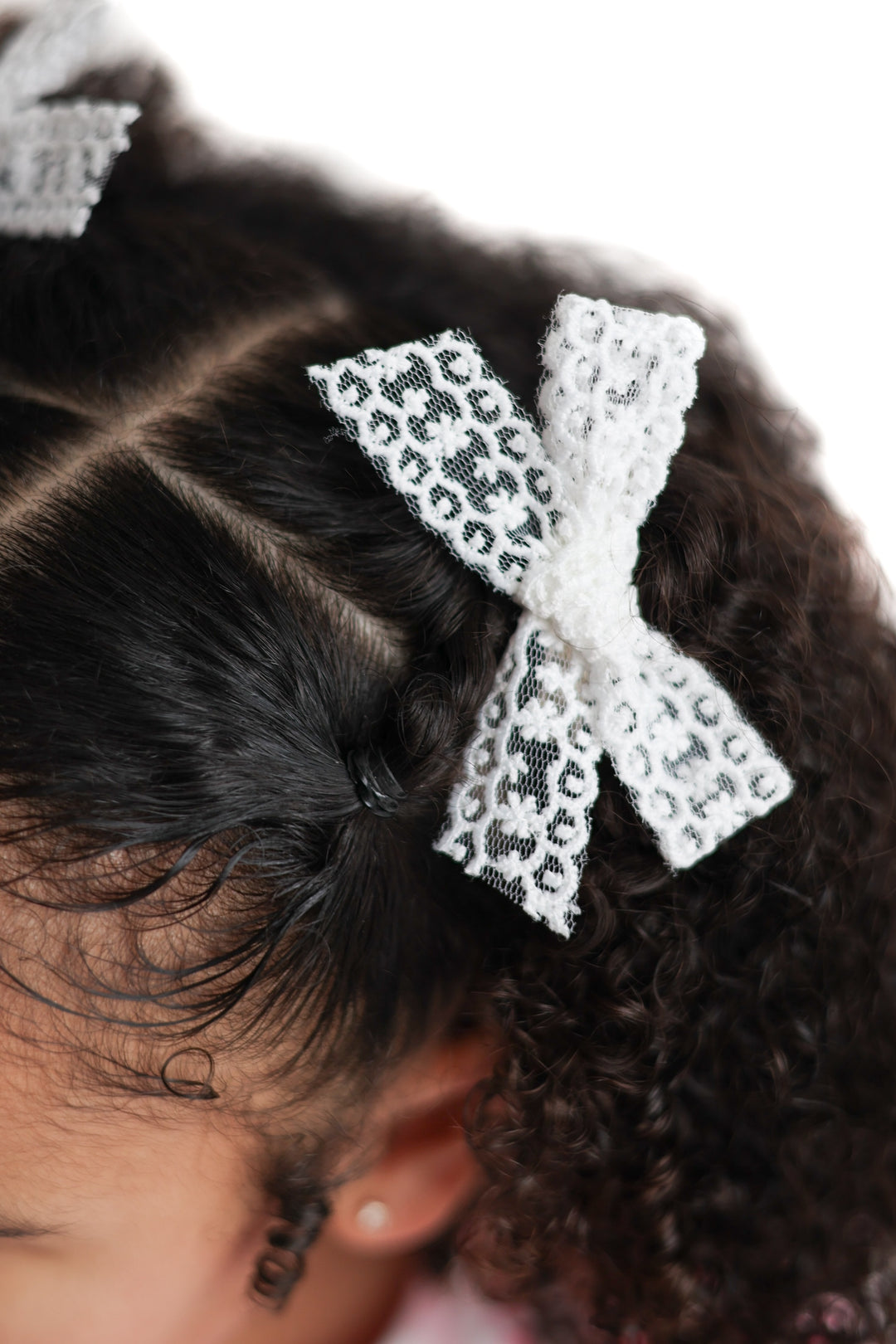 little girl in white lace pigtail bows on clips 