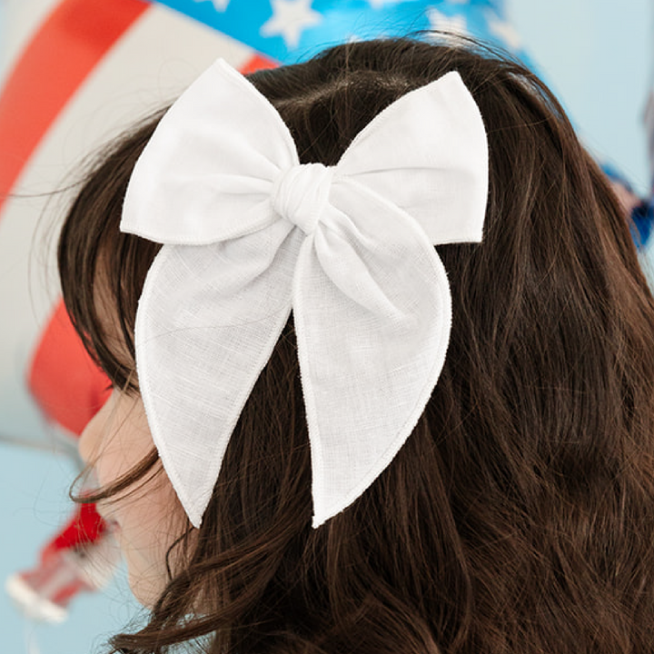 girl wearing 6" white linen hair bow 