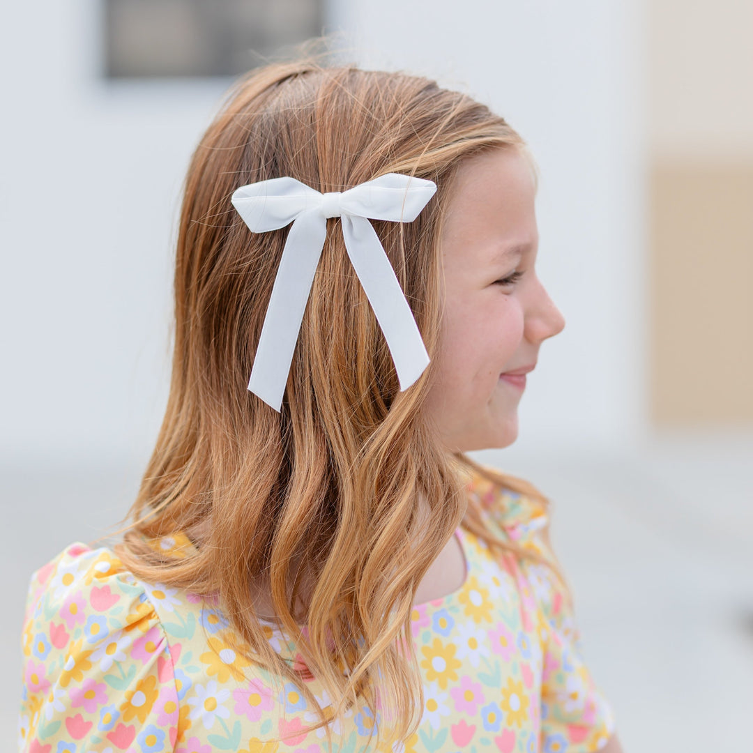 girl in yellow floral easter dress and white velvet ribbon hairbow on clip for spring