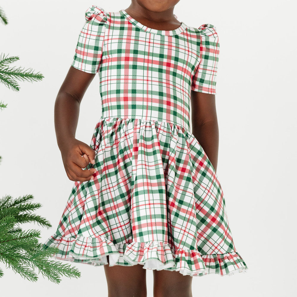 little girl wearing white, green and red christmas plaid twirl dress