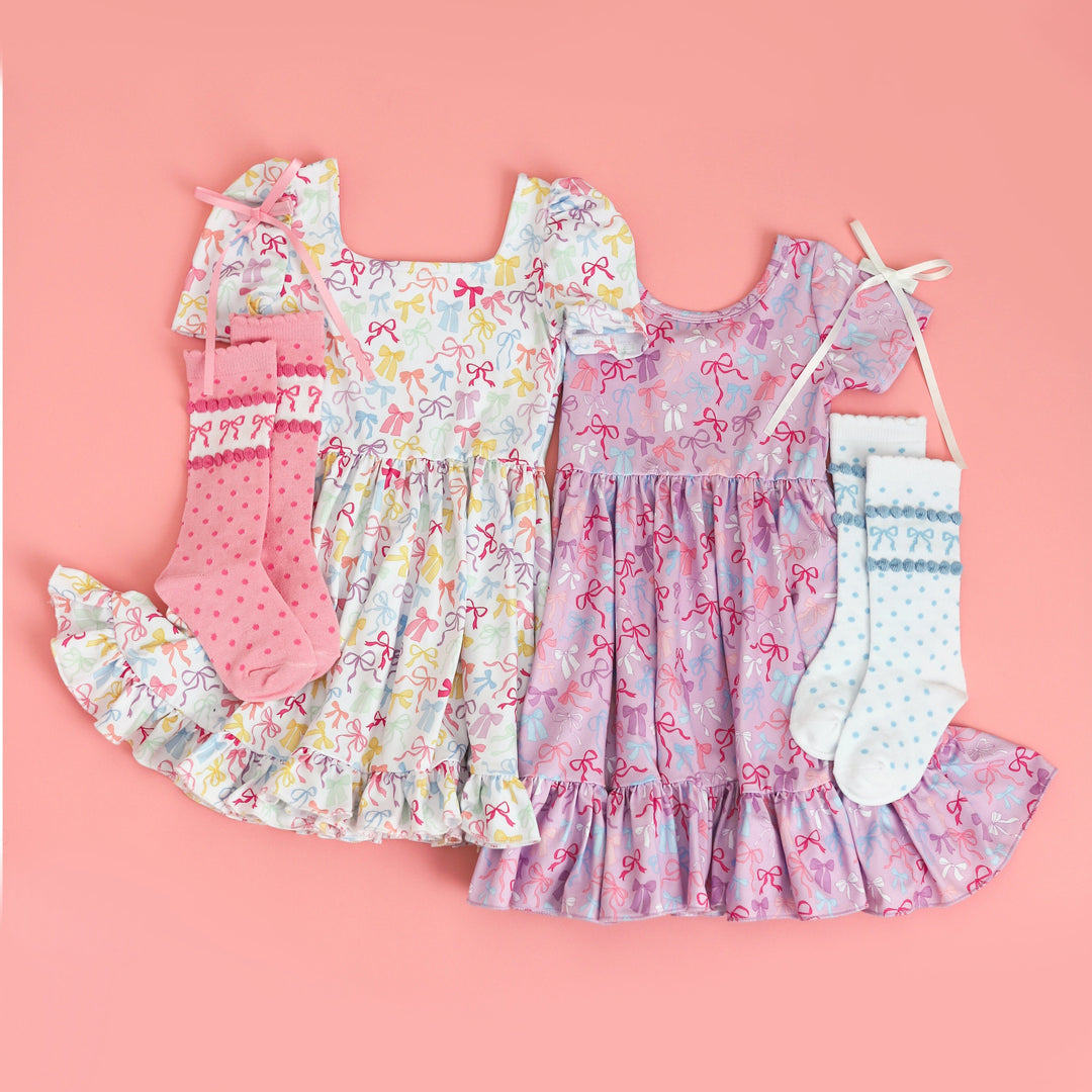 girls bow print twirl dresses in white and purple for spring with coordinating bow knee highs and satin bows on clips