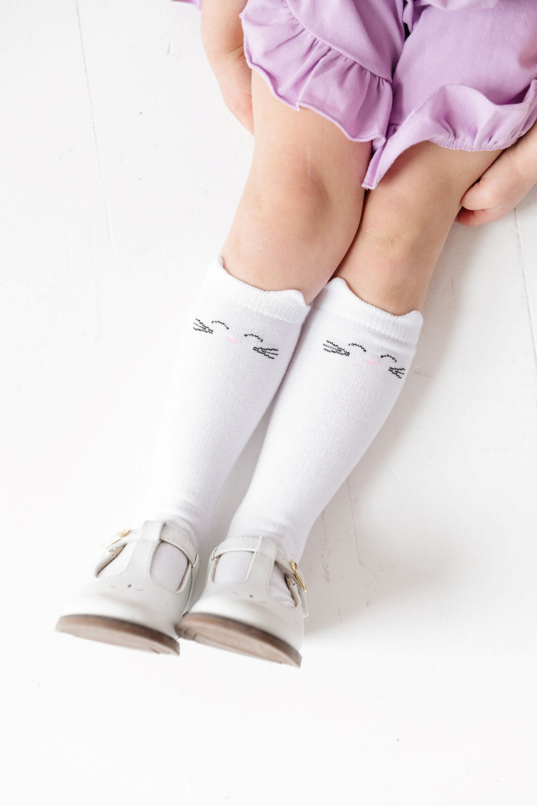 little girl in white knee highs socks with kitty face design and ears