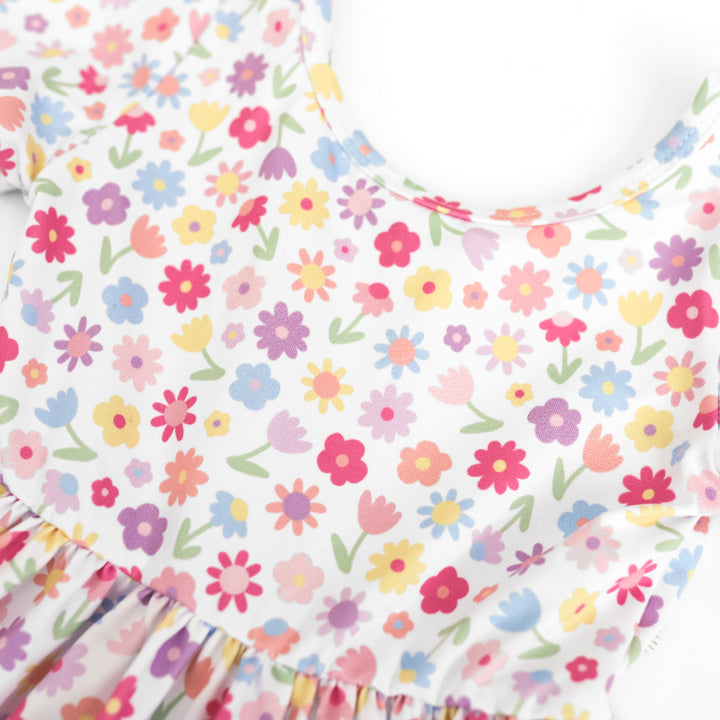 closeup of girl's white with pastel floral print spring dress