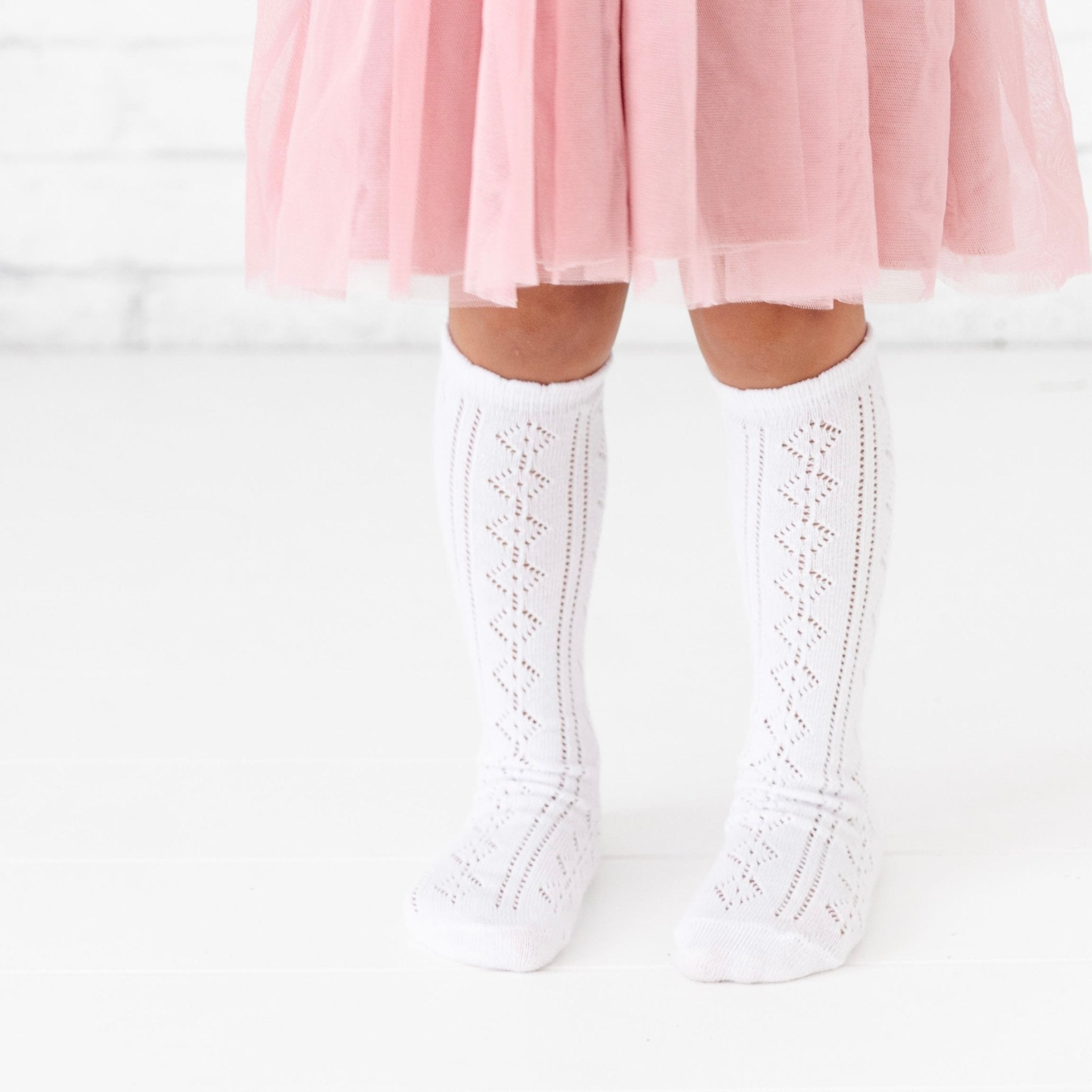 Little girl wearing tutu dress and crochet knit white knee high socks