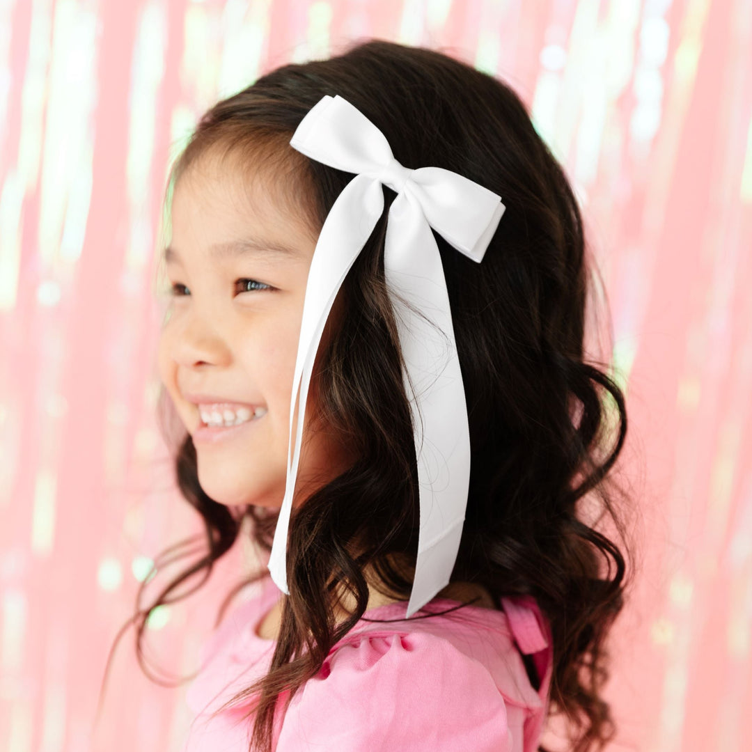 girl in white satin ribbon bow and pink twirl dress for Valentine's Day and spring