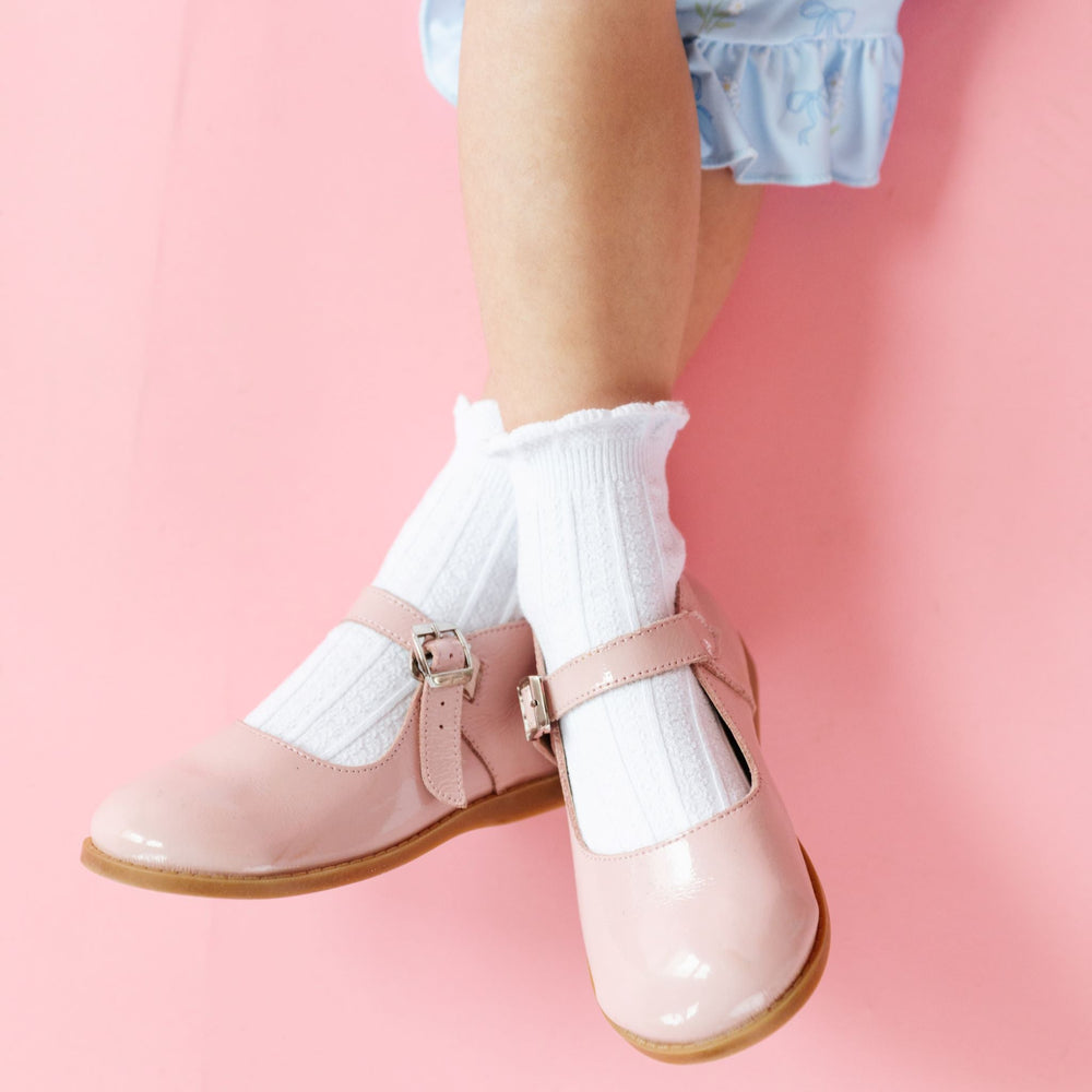 little girl in white scallop trimmed midi socks paired with blue spring dress and pink patent leather shoes