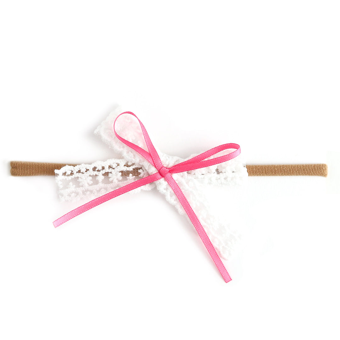 baby girls' white lace bow with pink satin ribbon detail on nylon