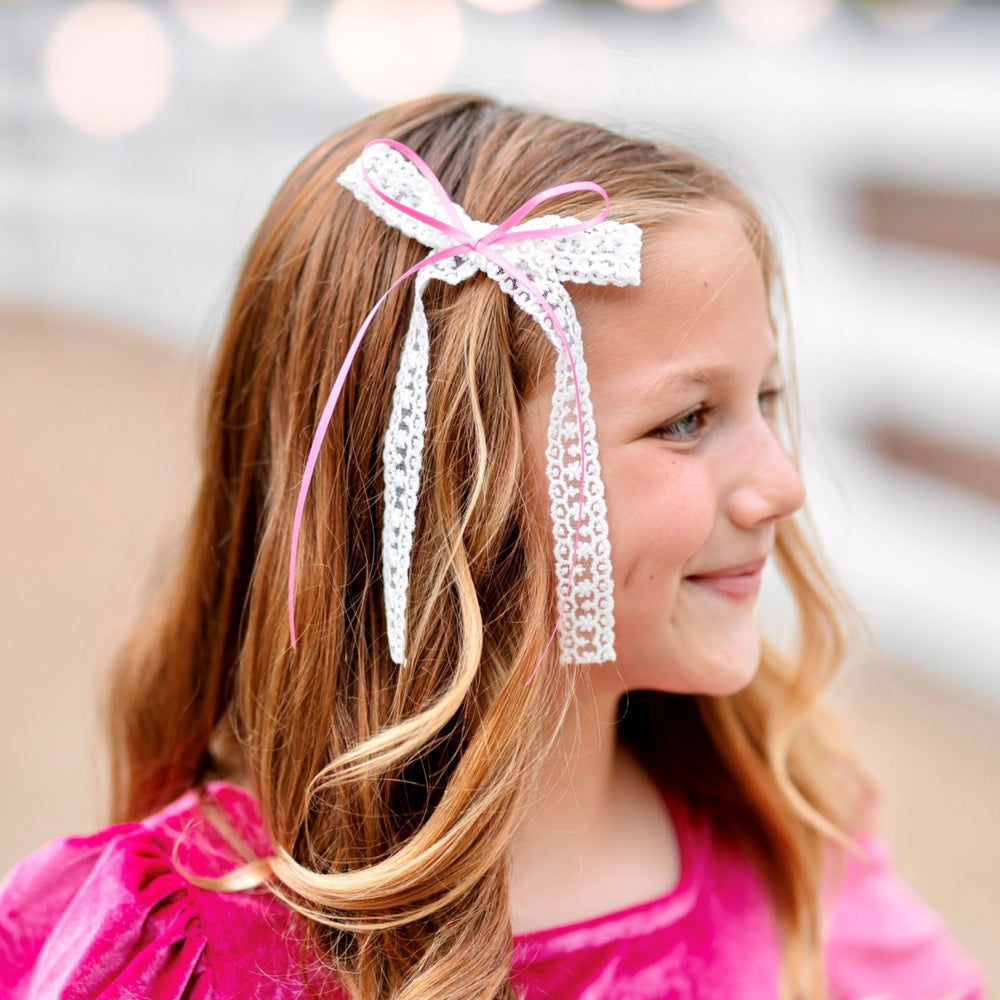 young girl with white long tail lace bow and pink satin ribbon on clip paired with pink velvet tut dress for pink Christmas