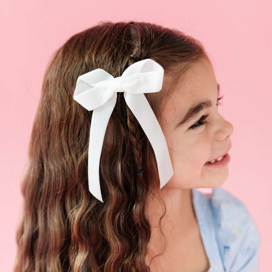 little girl in blue floral easter dress and white velvet ribbon hairbow on clip for spring