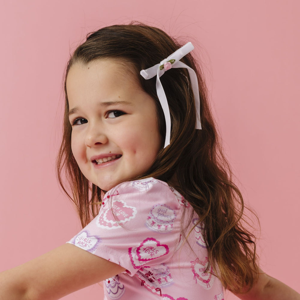 little girl in rosette white velvet ribbon bow with light pink flower paired with light pink valentines twirl dress
