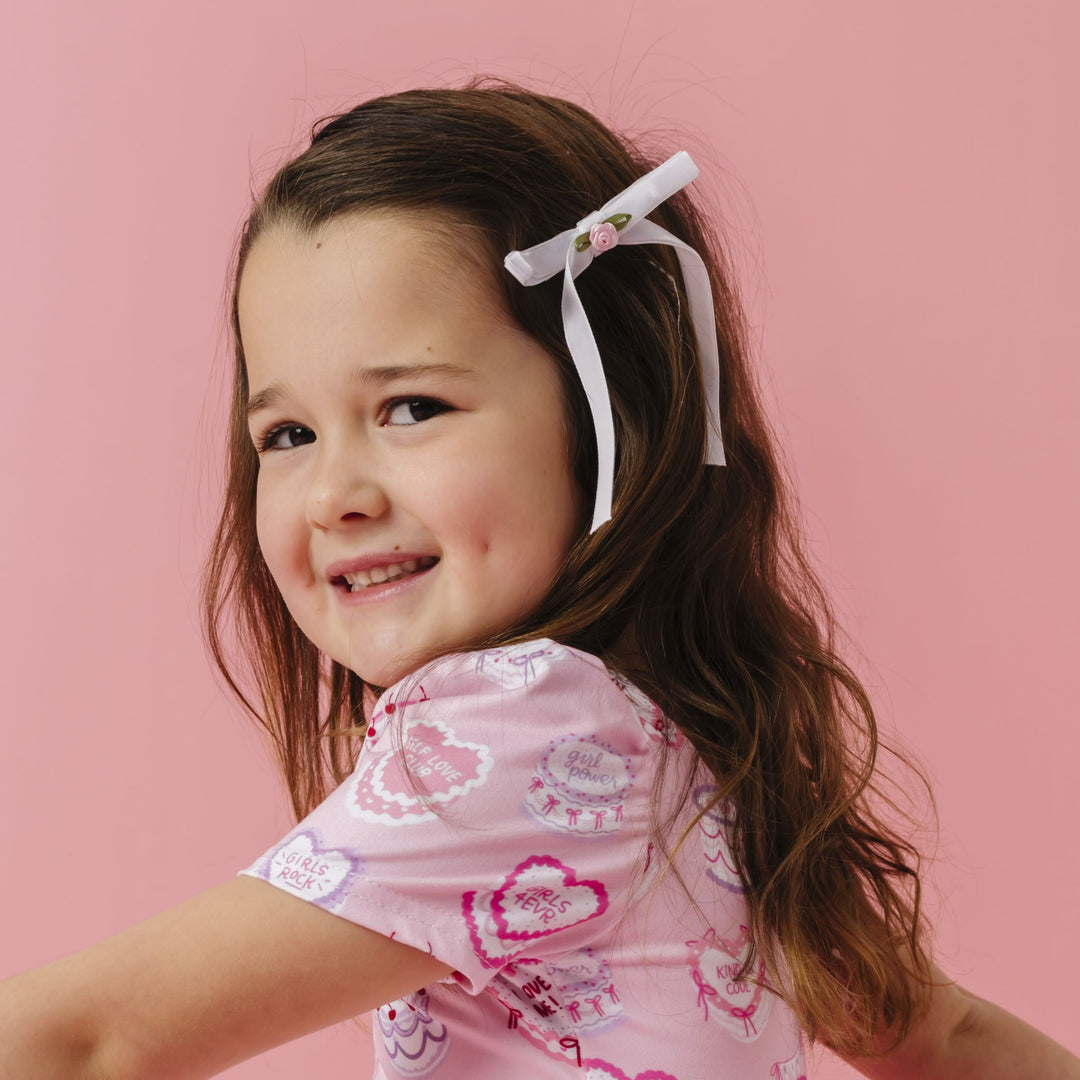 little girl in rosette white velvet ribbon bow with light pink flower paired with light pink valentines twirl dress