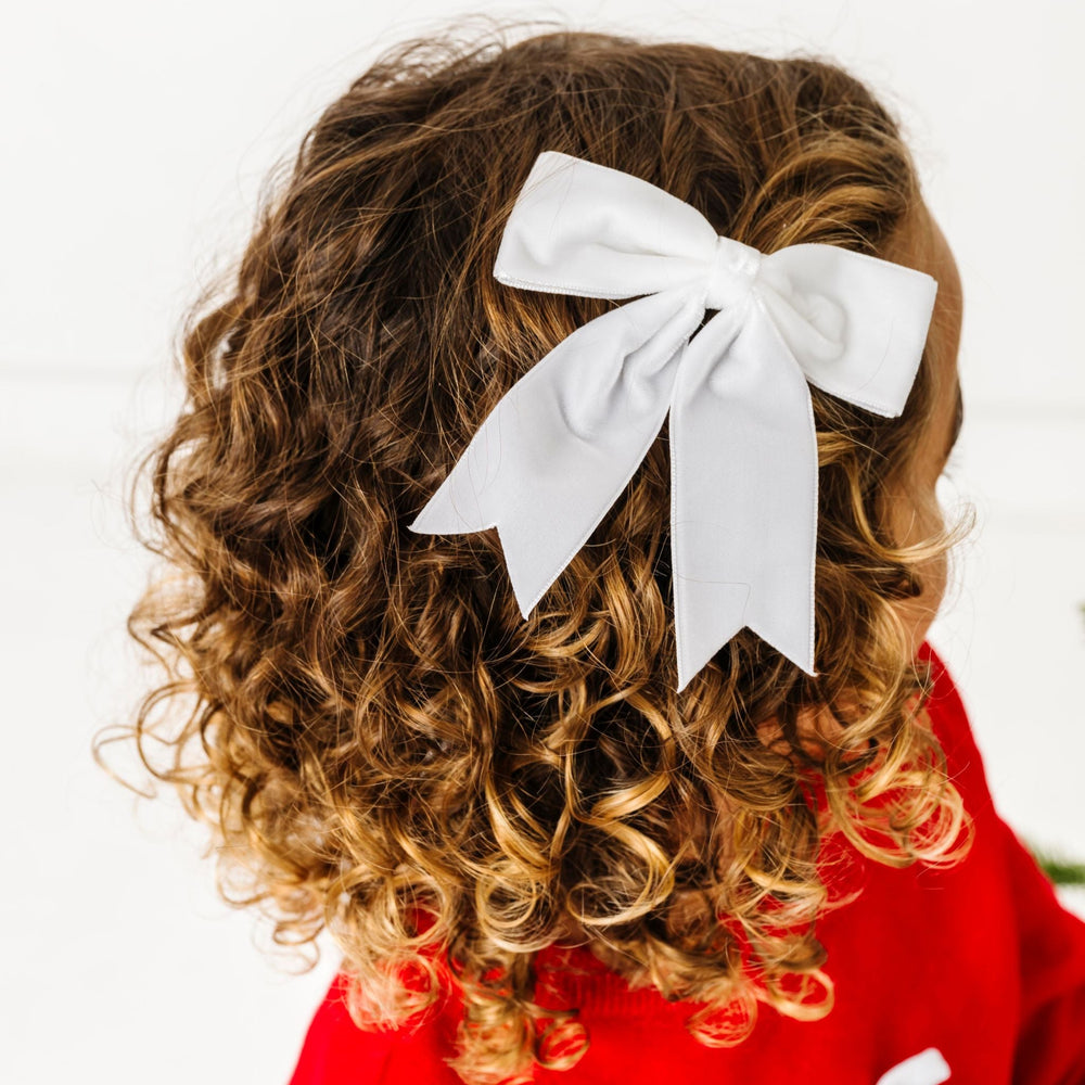 little girl in winter white velvet ribbon bow with dovetails paired with red Christmas sweater