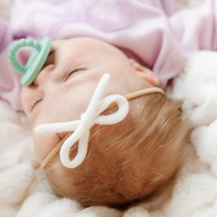 baby girl in white yarn knit bow on nylon headband and lavender bow spring sweater set