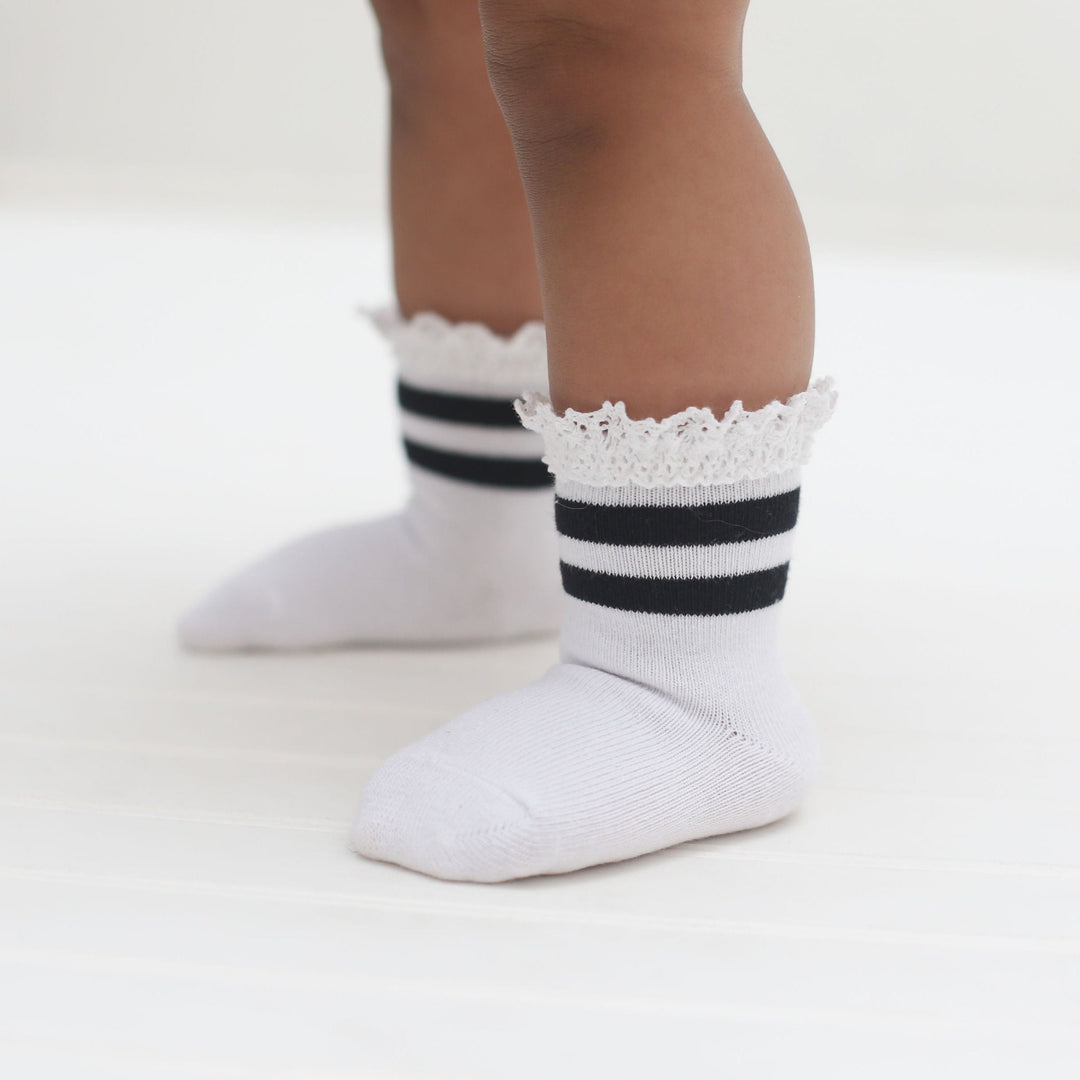 toddler standing in white and black striped lace midi socks