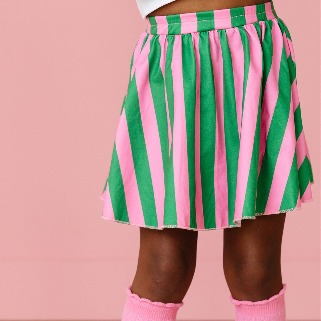 girl wearing pink and green striped skort