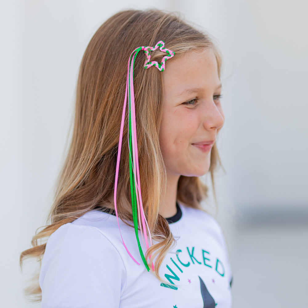 girl in Wicked Cute tee and matching braided star clip with ribbon streamers in shades of pink and green