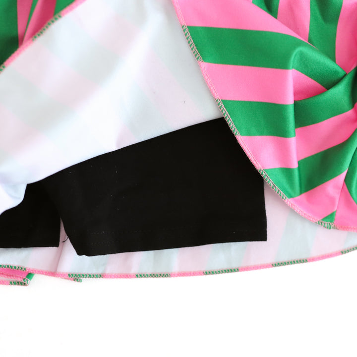 close-up of black built in biker shorts attached to pink and green striped skort 
