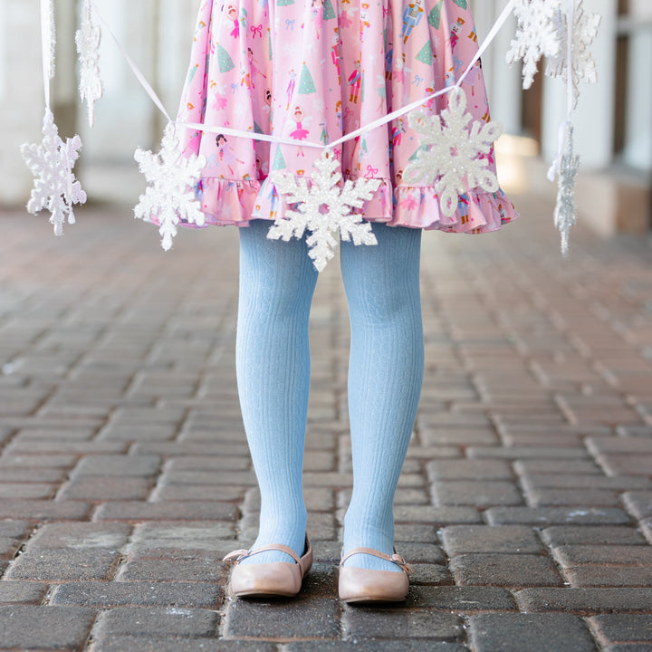 little girl in light blue cotton cable knit tights with matching pastel nutcracker inspired dress