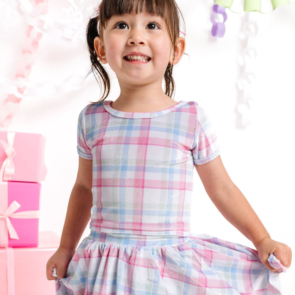 little girl in white velvet plaid top in shades of pink, blue and green for winter wonderland Christmas collection