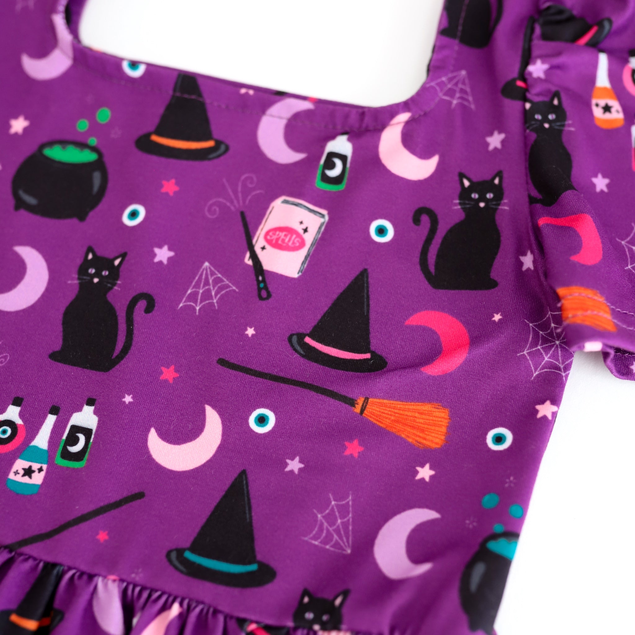 close-up of girls' square neck purple Halloween dress with witch themed print
