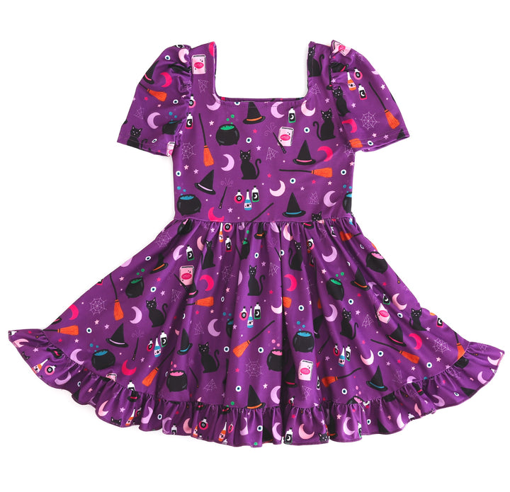 girl's square neck, puff sleeve twirly Halloween dress in purple with witches hats, black cats, cauldrons and other witchy themed print details