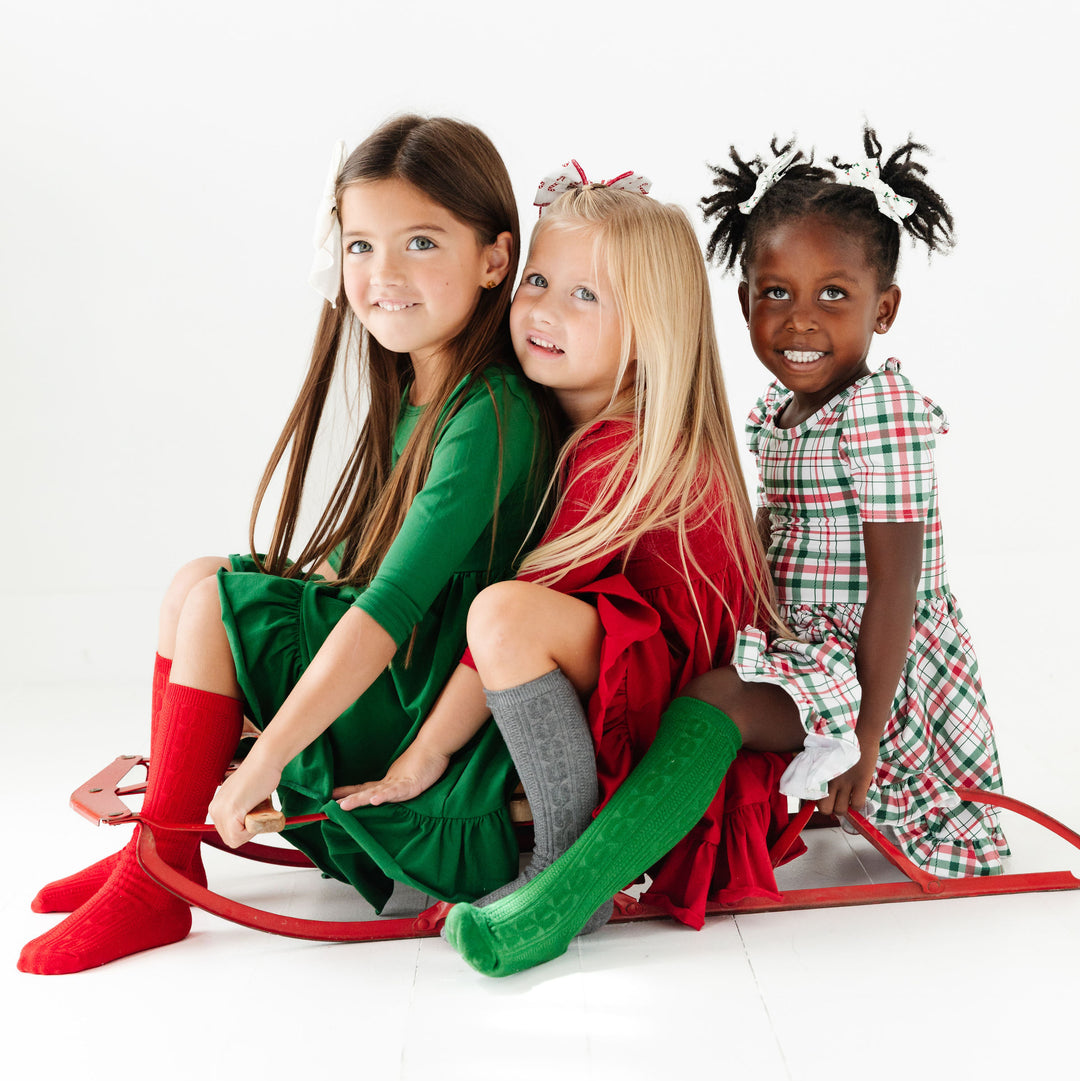 little girls wearing cable knit knee high socks with christmas dresses