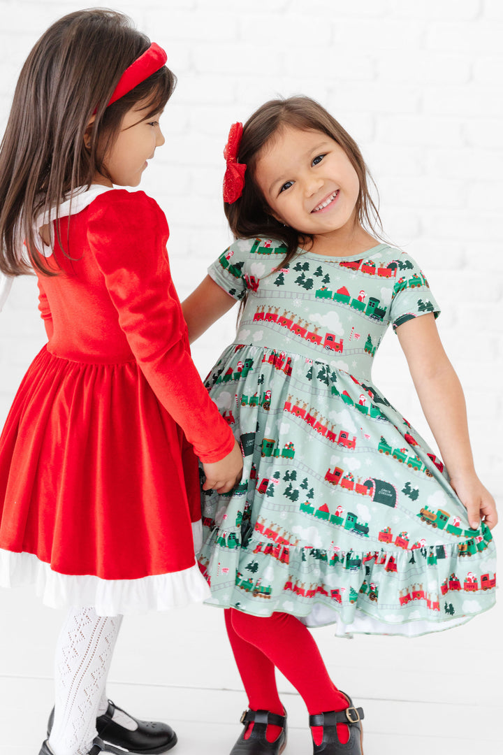 girls wearing christmas trains and santa dresses