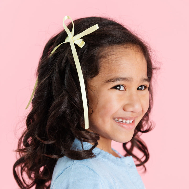 little girl in yellow satin long tail ribbon bow on alligator clip for spring