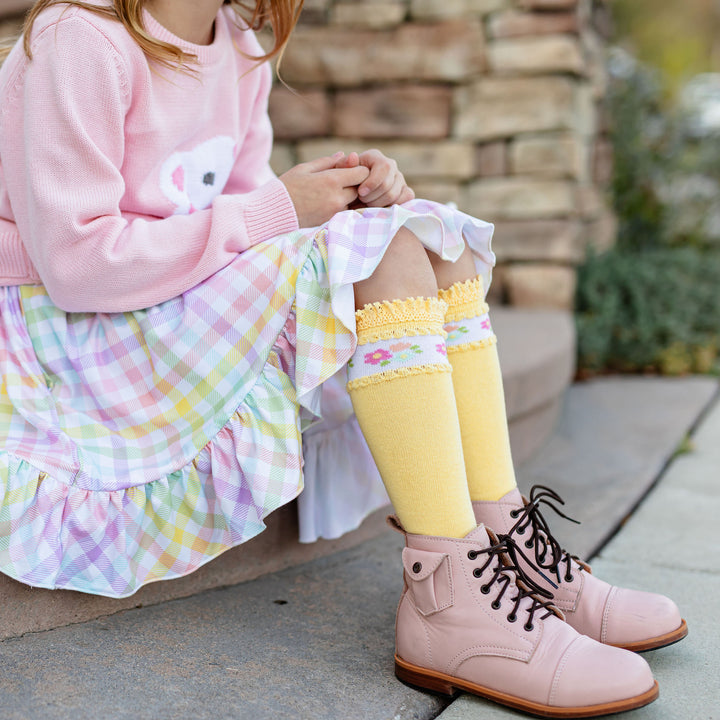 girl in easter outfit and yellow lace trimmed knee high socks with floral band around top