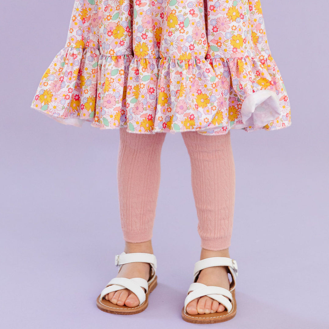 little girl in spring floral dress and adorable blush pink footless tights and white sandals