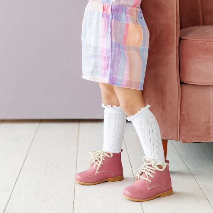 fancy white lace top knee highs socks on little girl in cute pink boots
